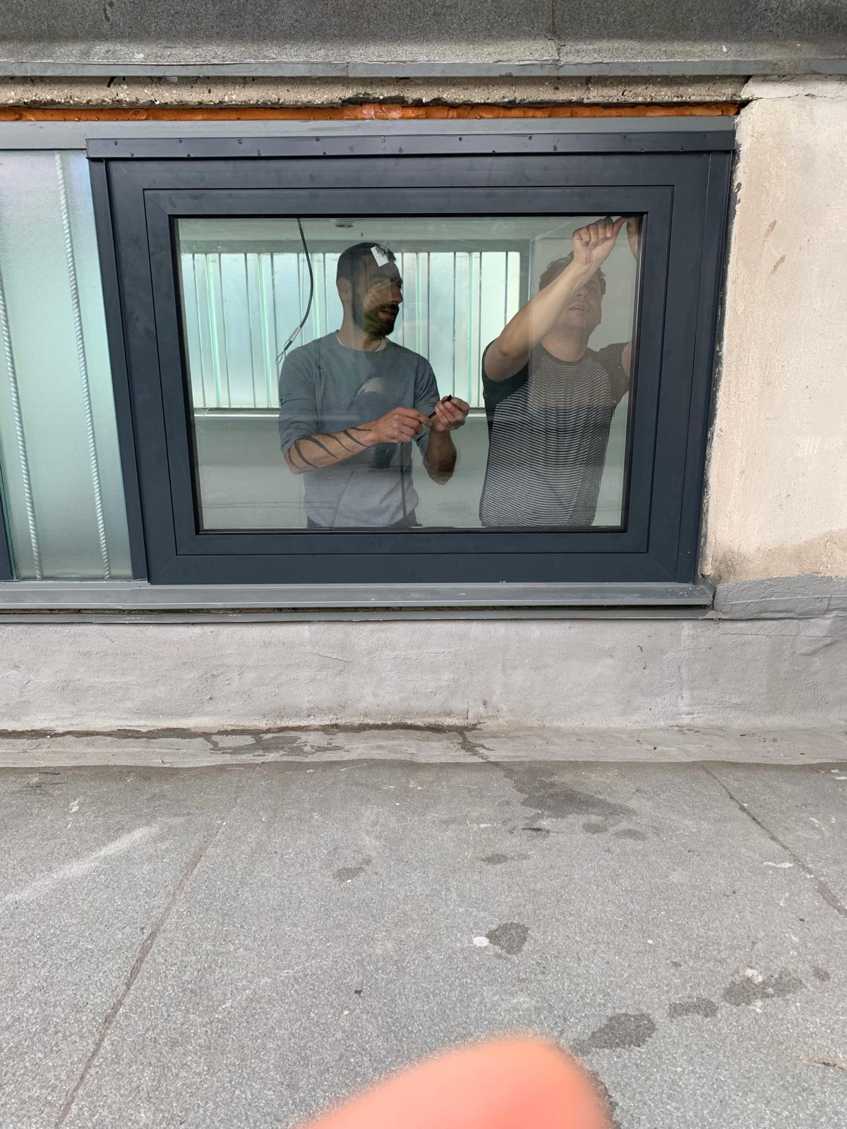Monteure justieren von innen ein neu eingebautes Fenster